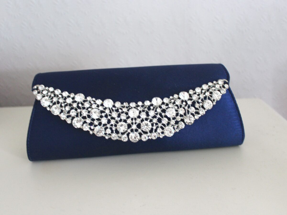 A photo of a dark blue clutch with silver embelishment on it