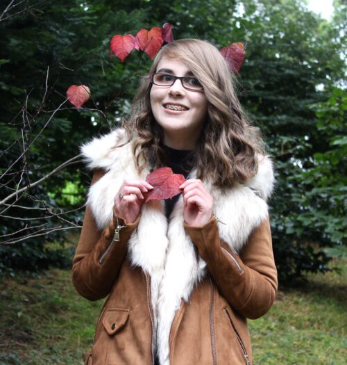 Photo of Elin holding a red heart shaped leaf
