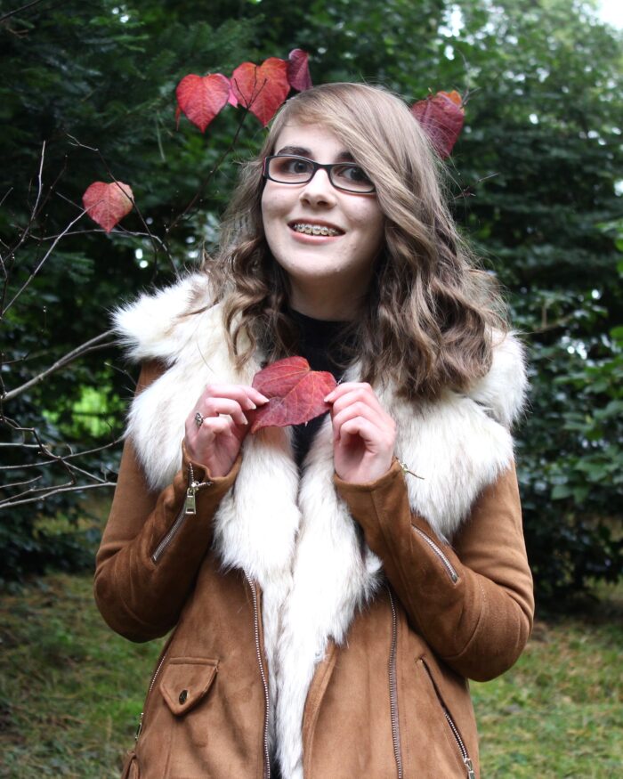 Photo of Elin holding a red heart shaped leaf