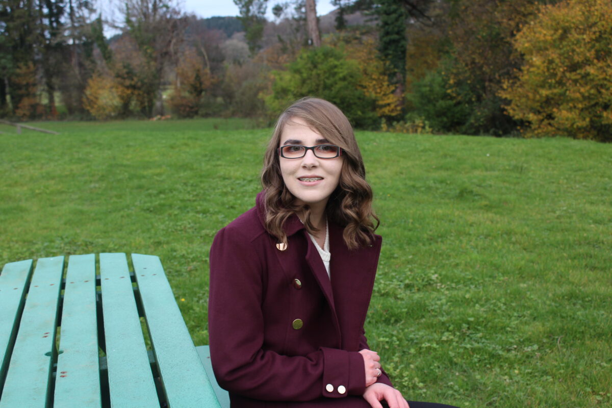 A photo of Elin sitting on a bench