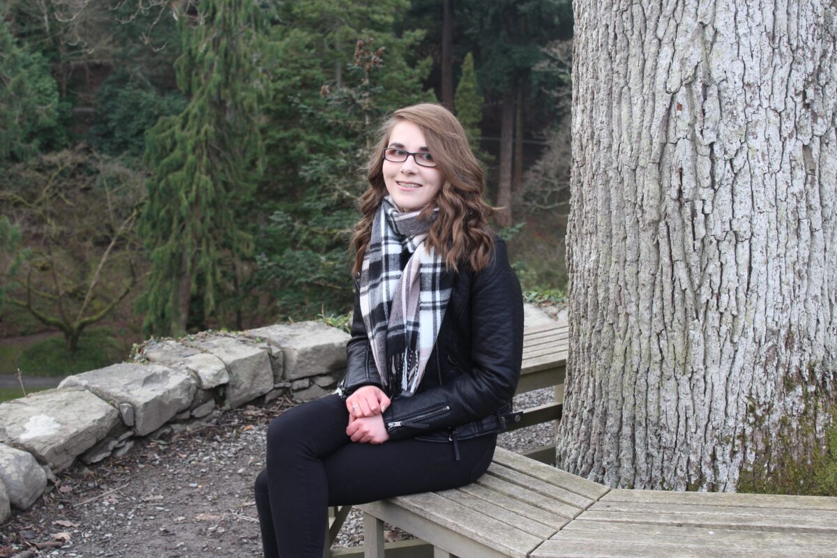 A photo of Elin sitting on a round bench