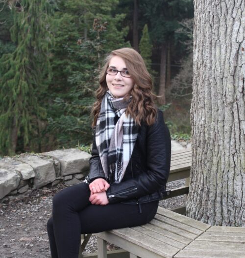 A photo of Elin sitting on a round bench