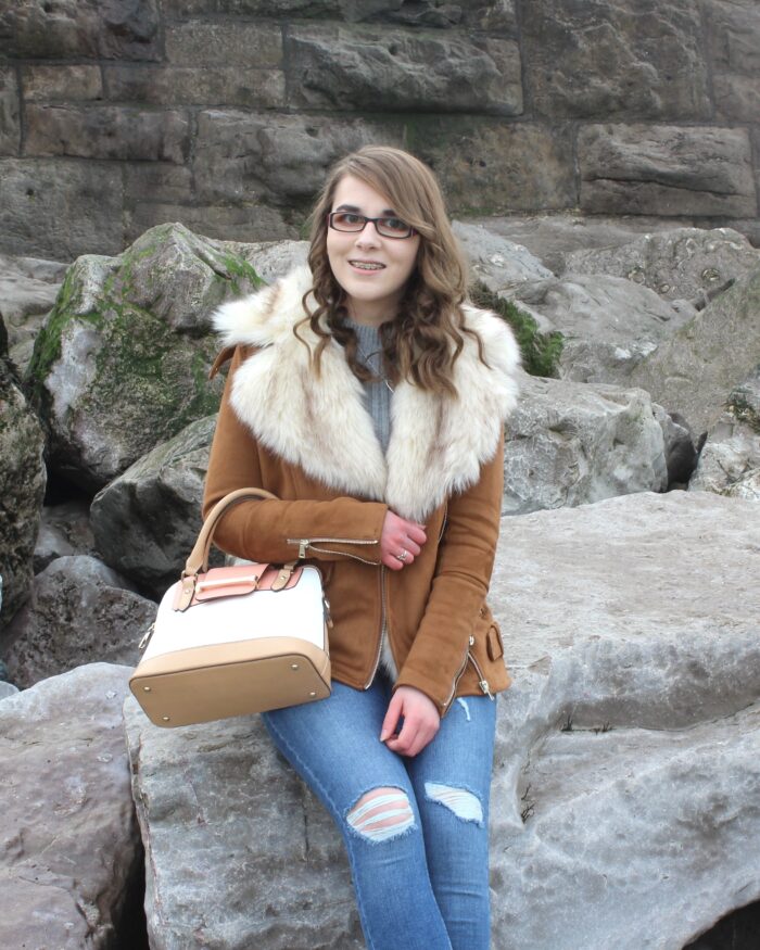 A photo of Elin sitting on rocks on the beach