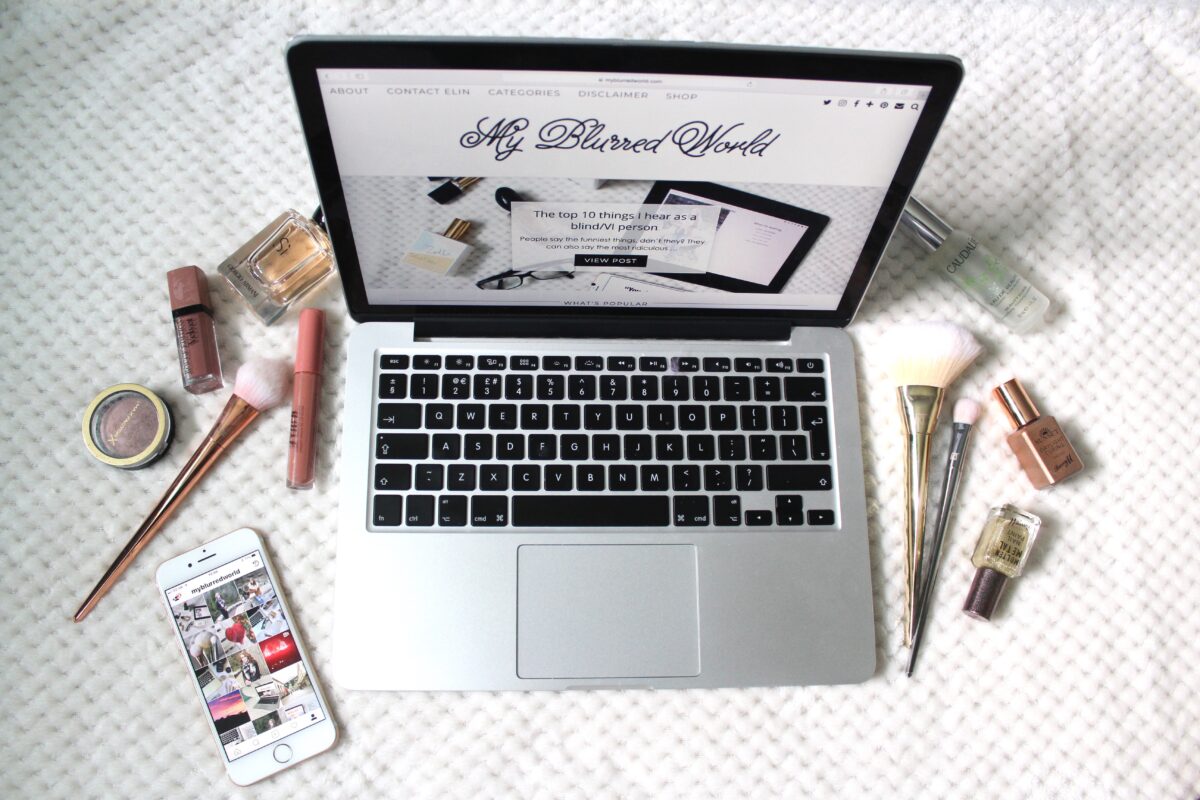A photo of my blog on a macbook, my instagram page on an iphone beside it and beauty products surrounding it