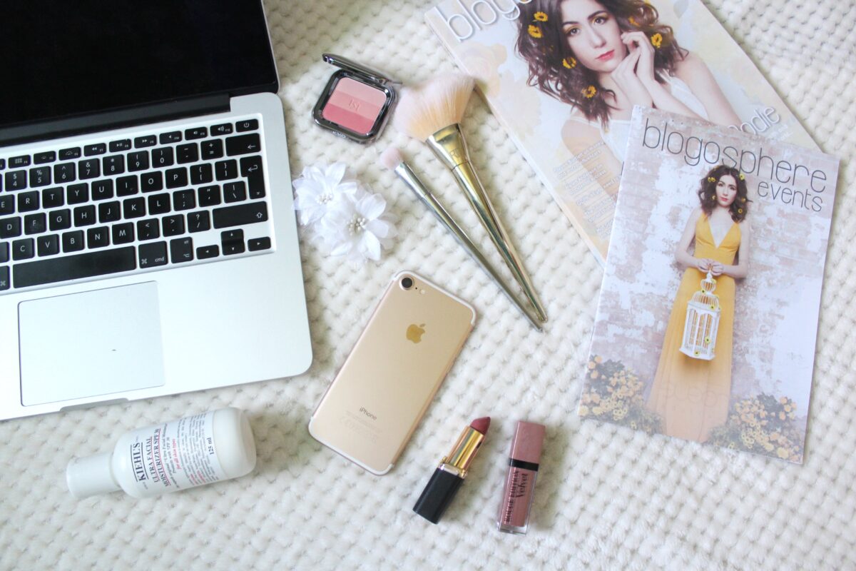 A photo of a macbook, iphone, beauty products and Blogosphere magazine