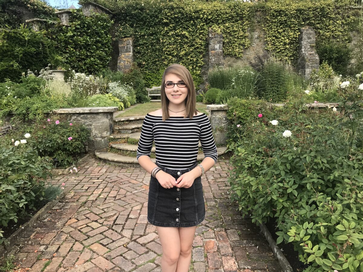 A photo of Elin wearing a black denim skirt and striped top