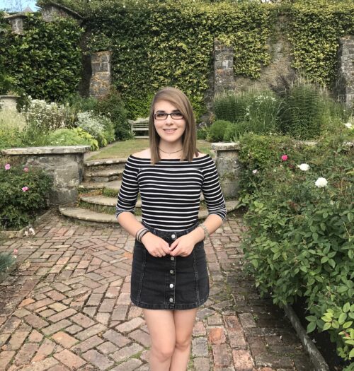 A photo of Elin wearing a black denim skirt and striped top