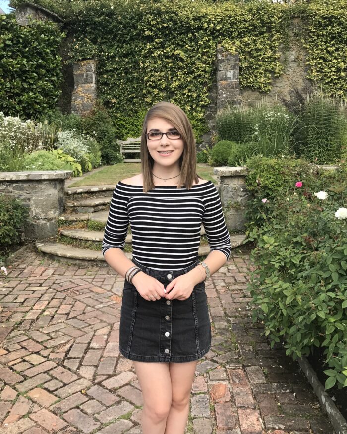 A photo of Elin wearing a black denim skirt and striped top
