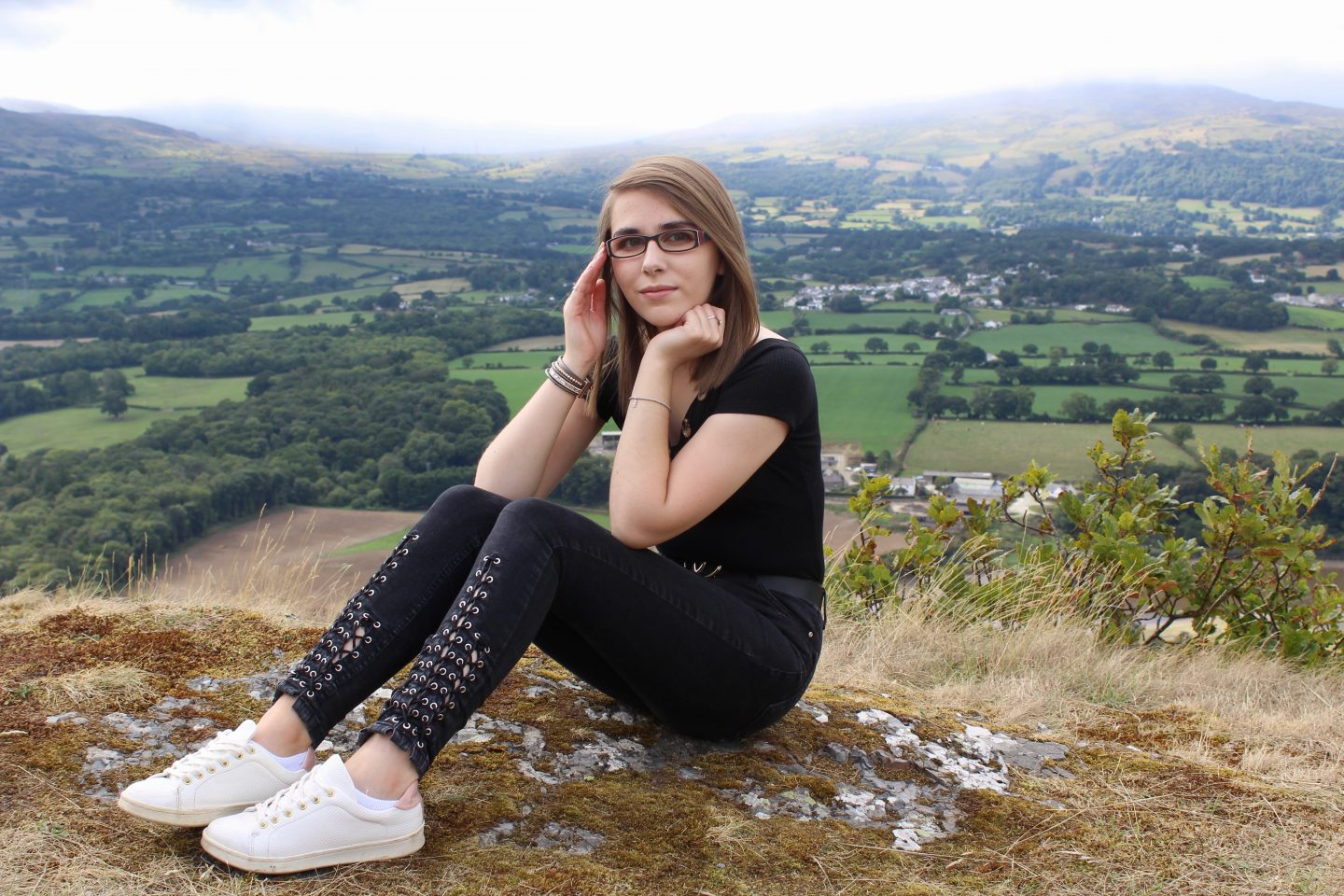 A photo of Elin wearing a black bardot top with black lace up skinny jeans