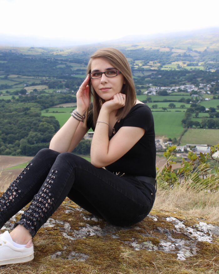 A photo of Elin wearing a black bardot top with black lace up skinny jeans