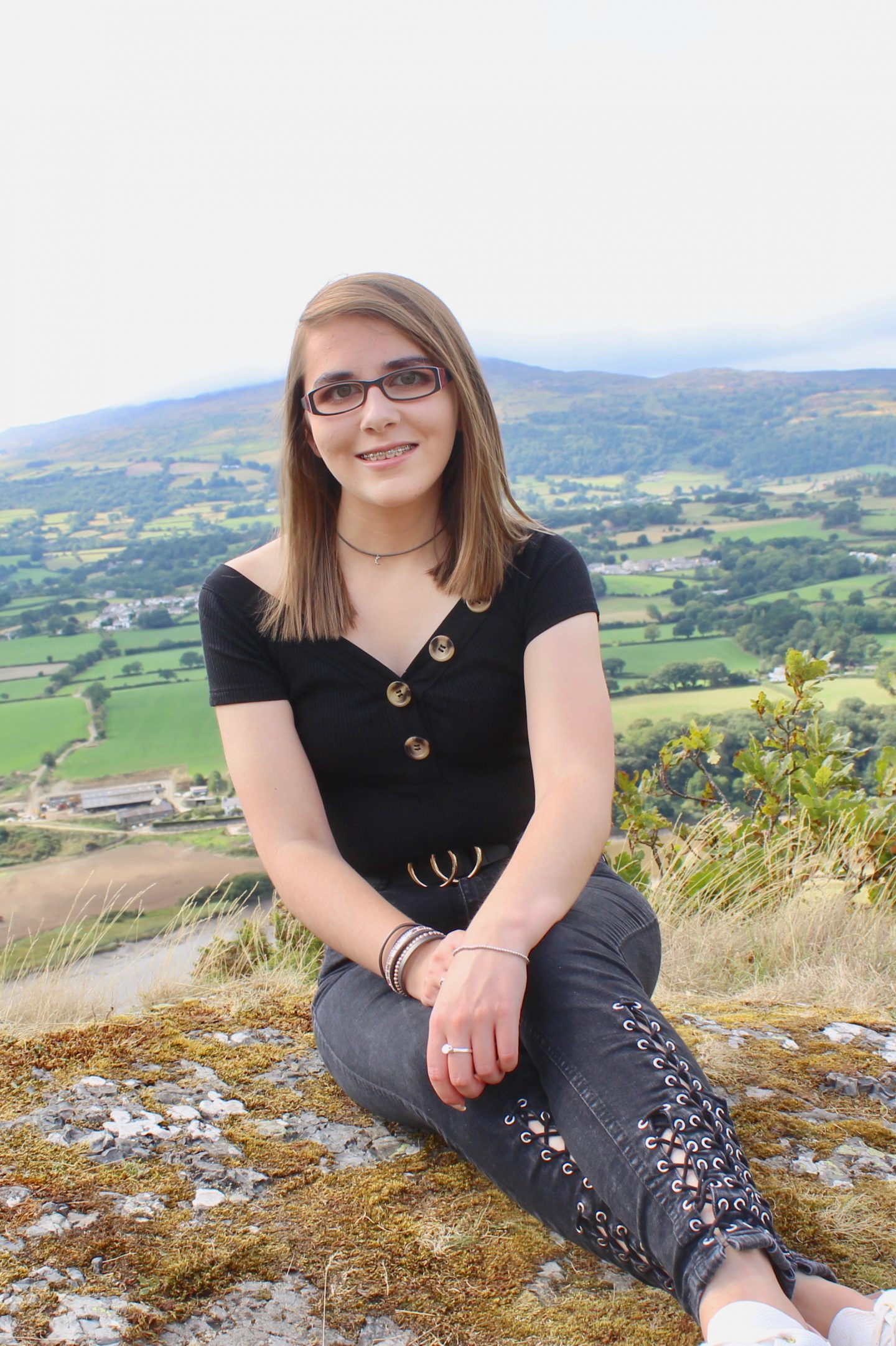 A portrait photo of Elin sitting down with mountains in the background