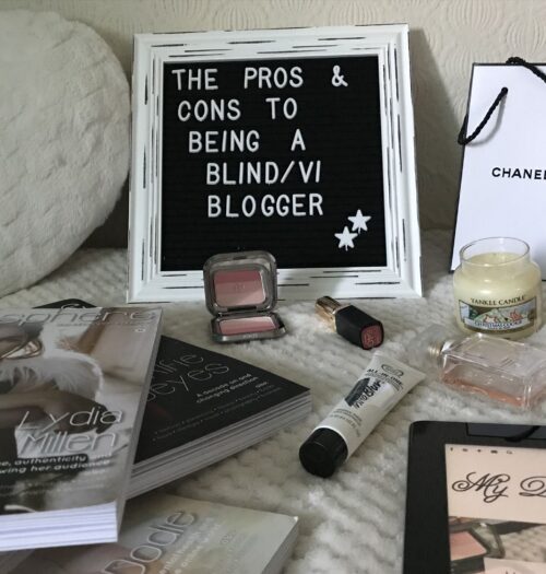 A photo of a white framed letter board which says the pros and cons to being a blind/VI blogger with beauty products in front of it and a few issues of blogosphere magazine