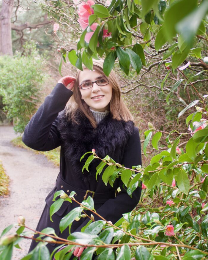 A photo of Elin amongst leaves and trees