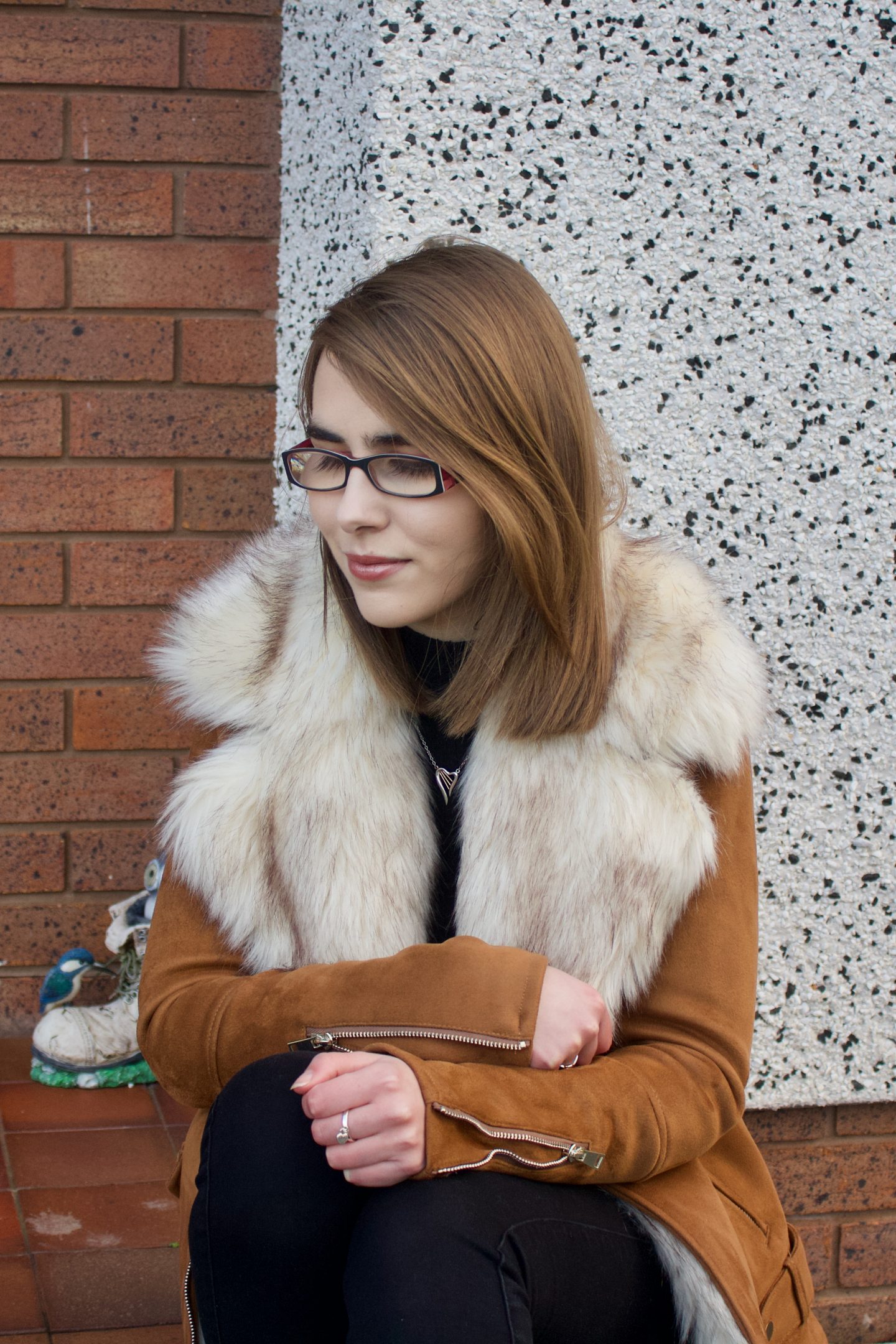 A photo of Elin sitting on a red coloured step and she is looking down