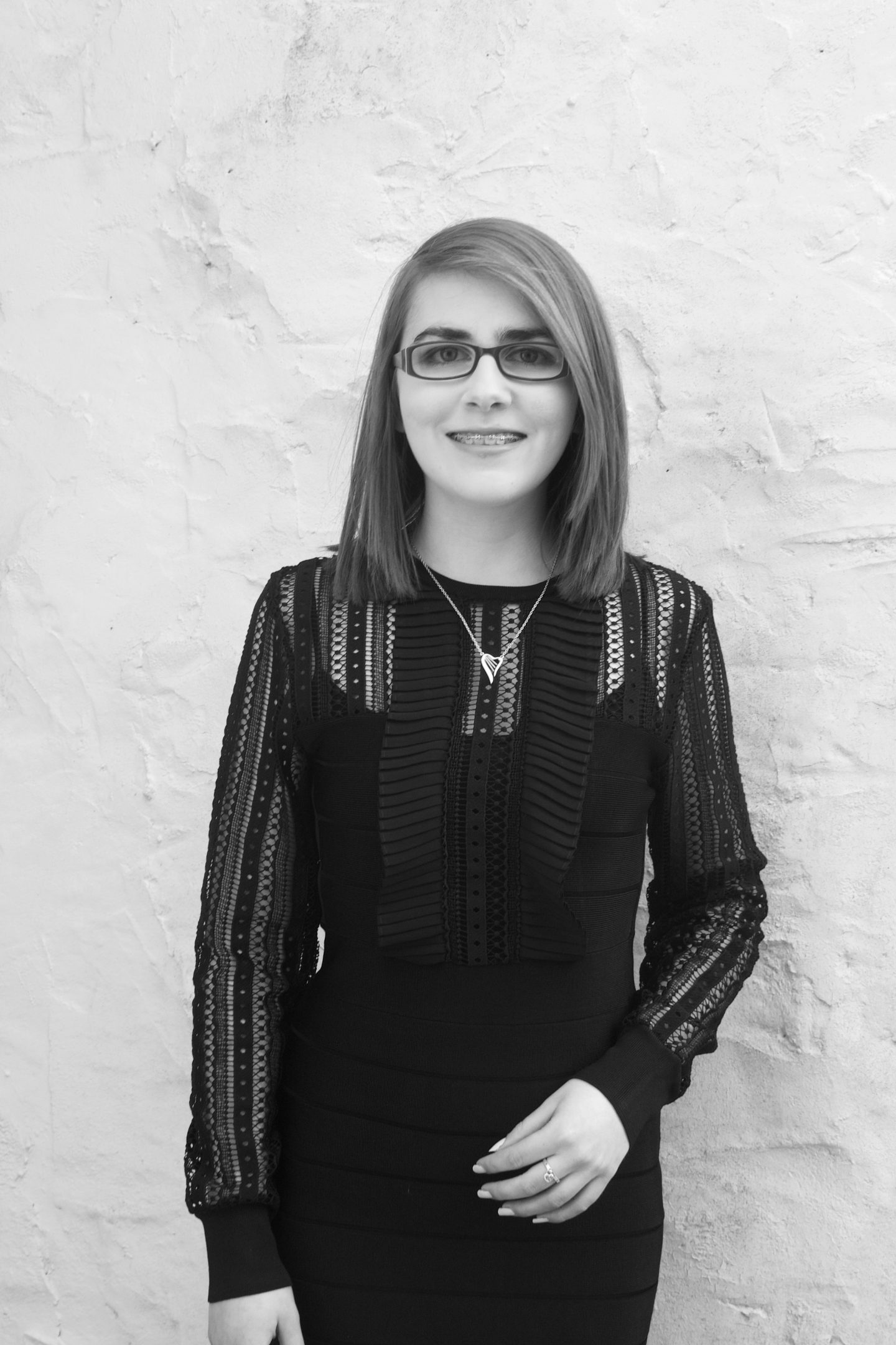 A black and white photo of Elin, she is wearing a black French Connection dress which has lace panel sleeves
