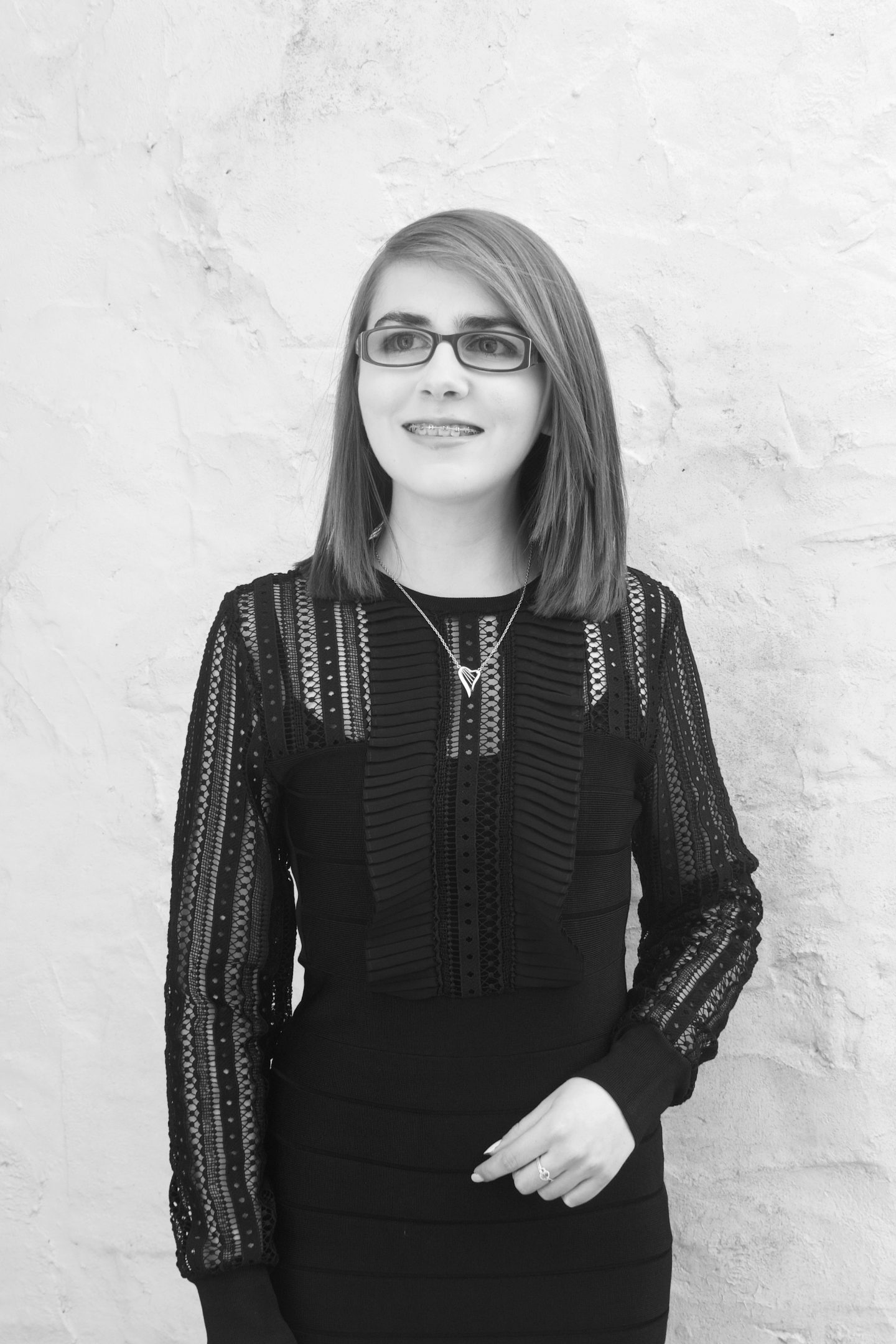 A black and white photo of Elin looking away from the camera and smiling