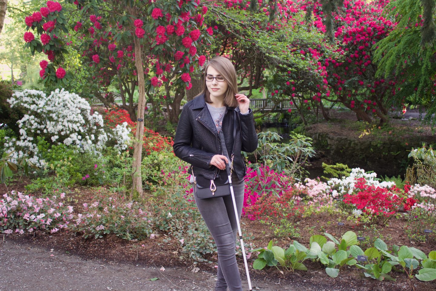 A photo of Elin holding her cane and looking down