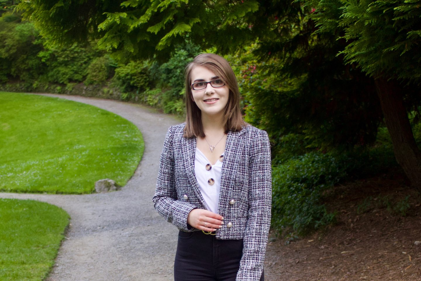 A photo of Elin with trees in the background which line a walking path