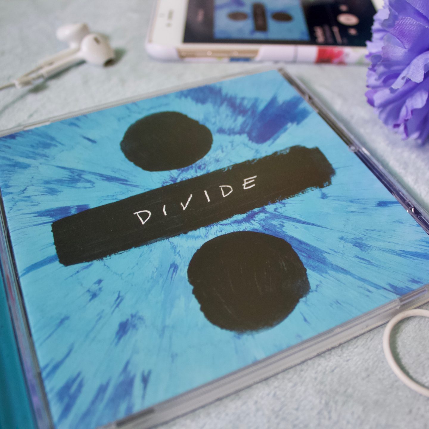 A photo of the Divide album case which is blue with a black divide symbol on it