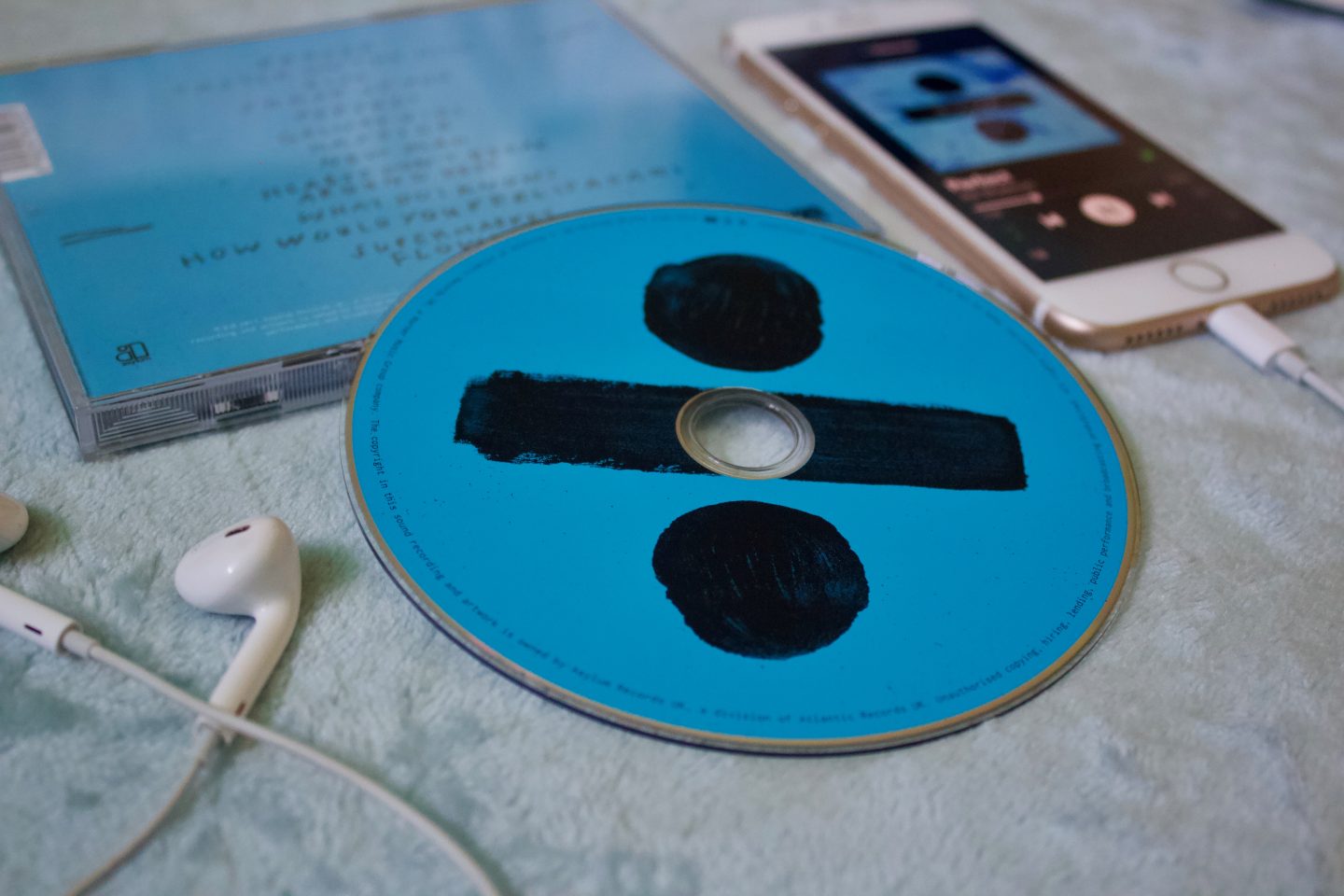 A photo of the Divide CD which is placed on the case which is upside down and showing the names of the songs on the album
