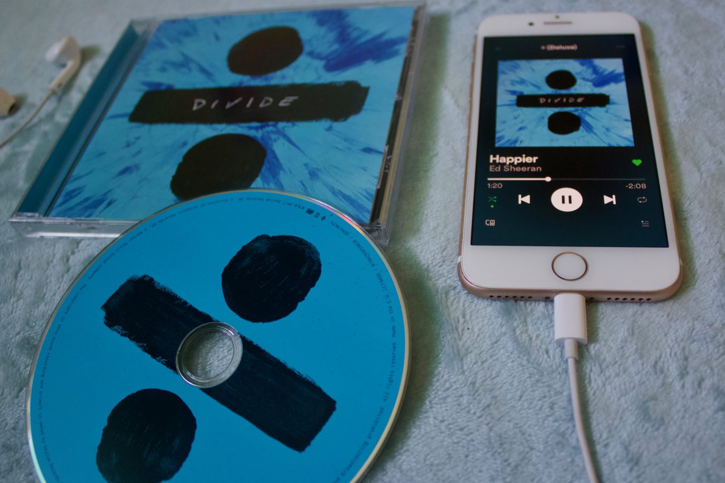 A photo of the Ed Sheeran Divide CD with my phone next to it which is playing the song Happier
