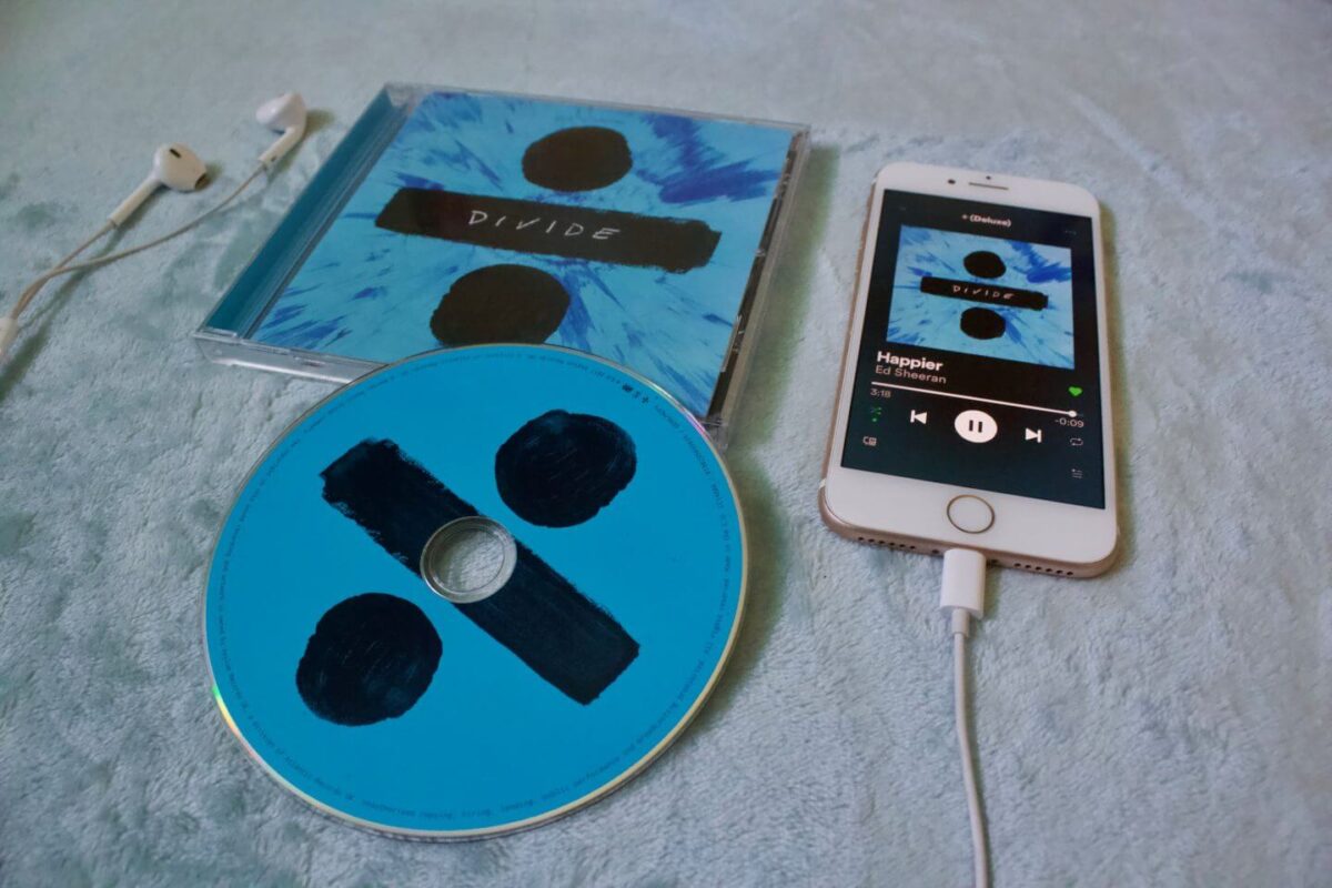 A photo of the Ed Sheeran Divide CD with my phone next to it which is playing the song Happier