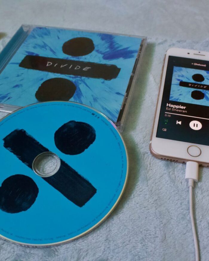 A photo of the Ed Sheeran Divide CD with my phone next to it which is playing the song Happier