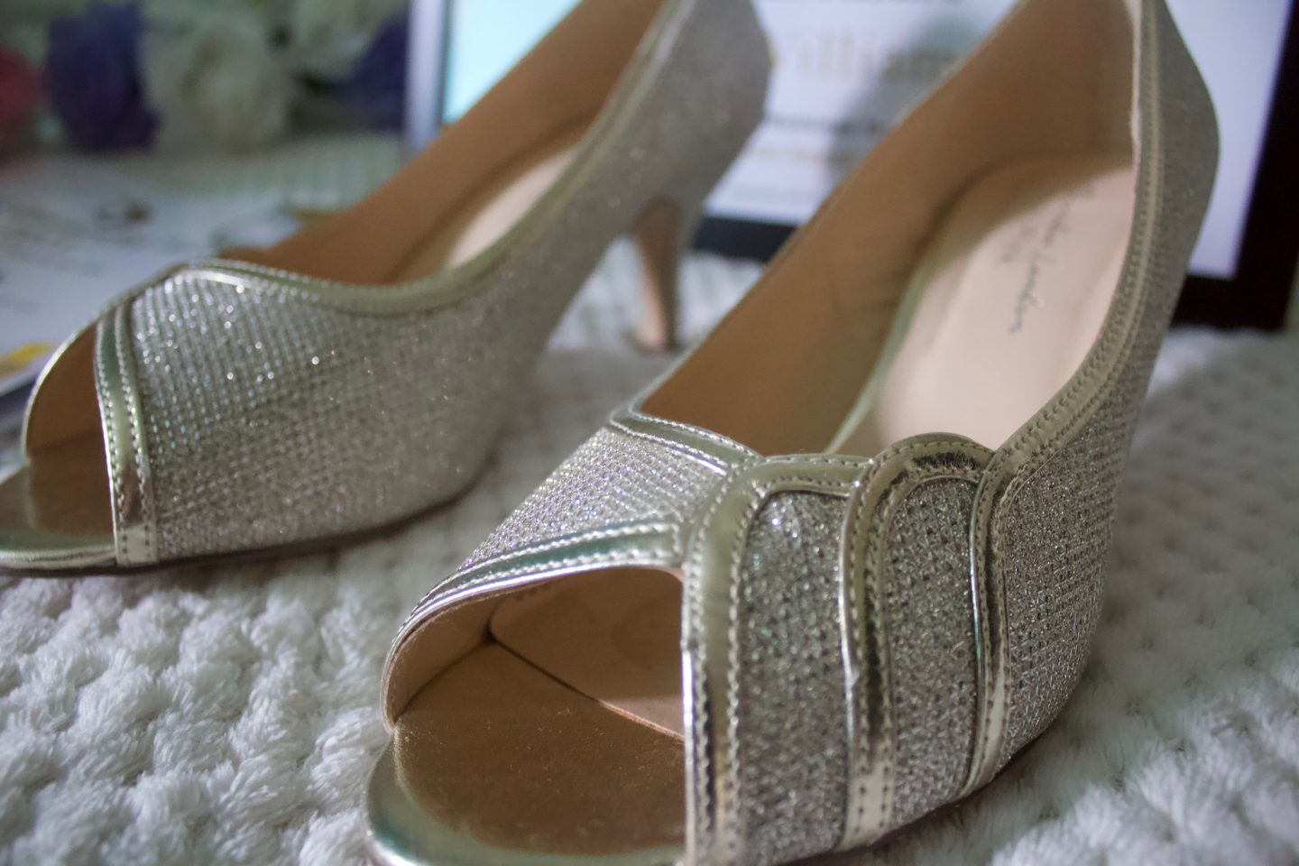 A photo of a pair of gold peep toe heels which has scallop detailing and a mid heel