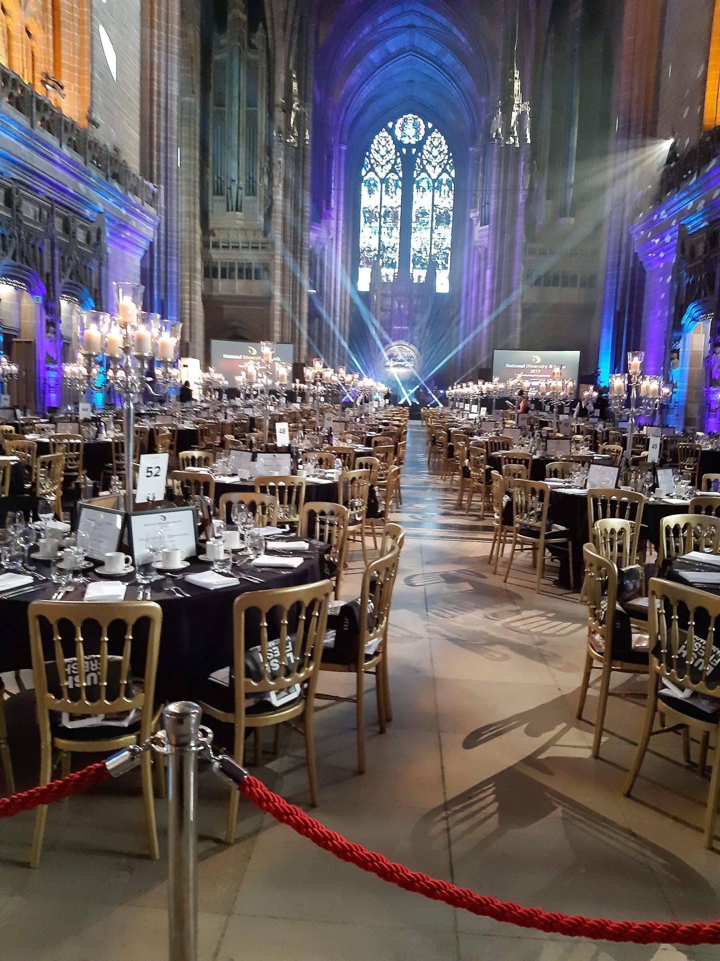 A photo of the east window with tables extending towards it - a blue light is cast over them