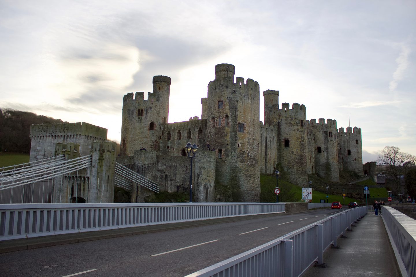 A photo of a castle with a suspension bridge leading up to it