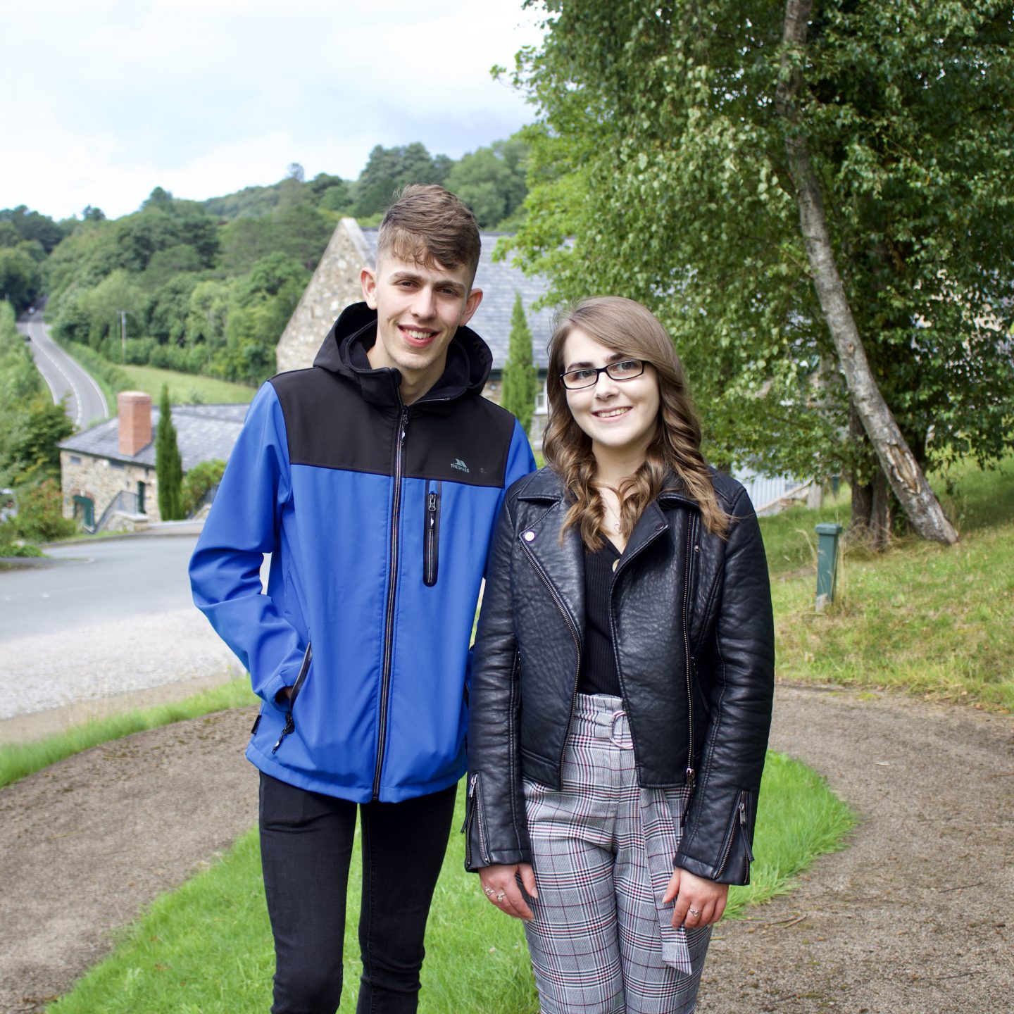 A photo of my brother and I standing in front of pretty buildings with trees framing the right side of the photo